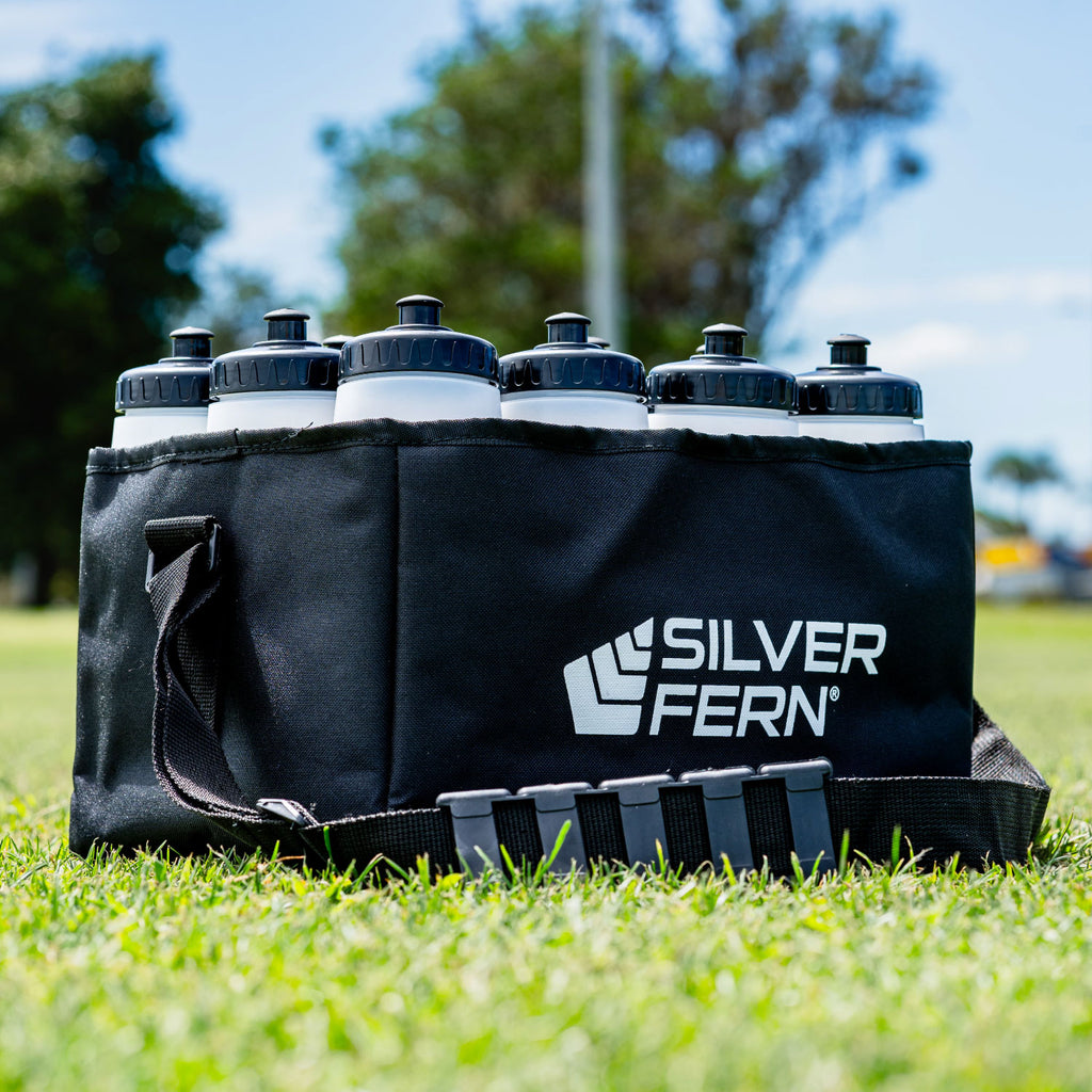 Drink bottle carrier fabric, 12 bottles capacity, bottle in drink carrier on field, lifestyle.