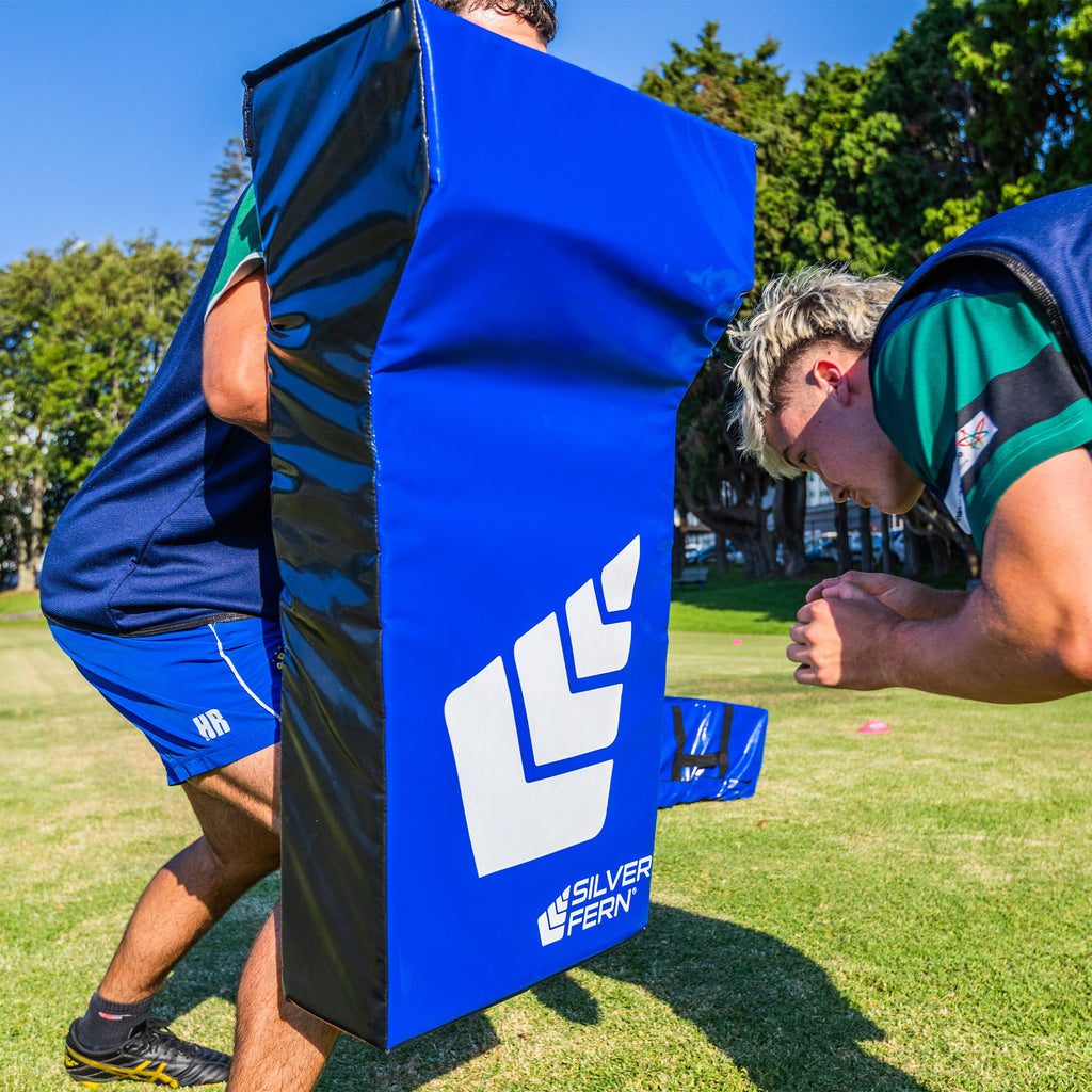 Hit Shield Wedge, rugby player about to tackle, another player holding the hit shield wedge, action lifestyle image.