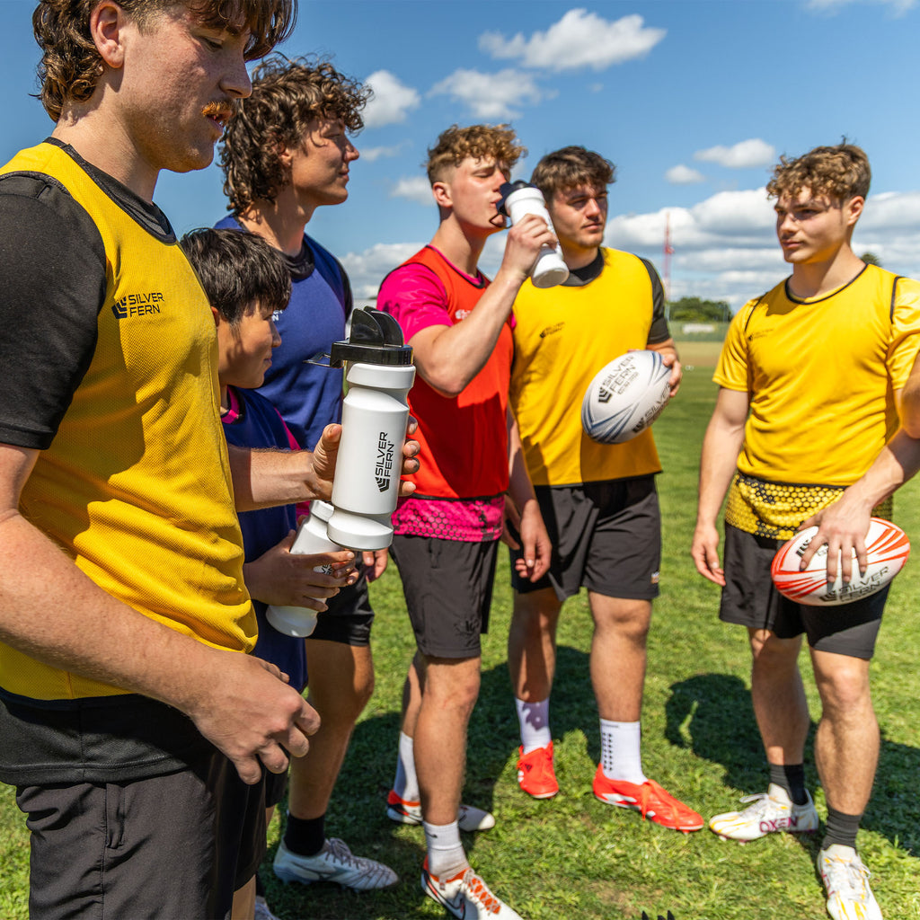 Hygiene drink bottle, group of rugby players drinking water out of the hygiene cap with chin rest, lifestyle. 