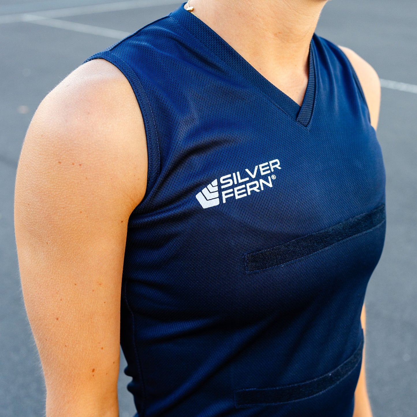 Close-up of a netball player wearing a navy blue dress uniform, focusing on the upper body and the Silver Fern logo on the chest.