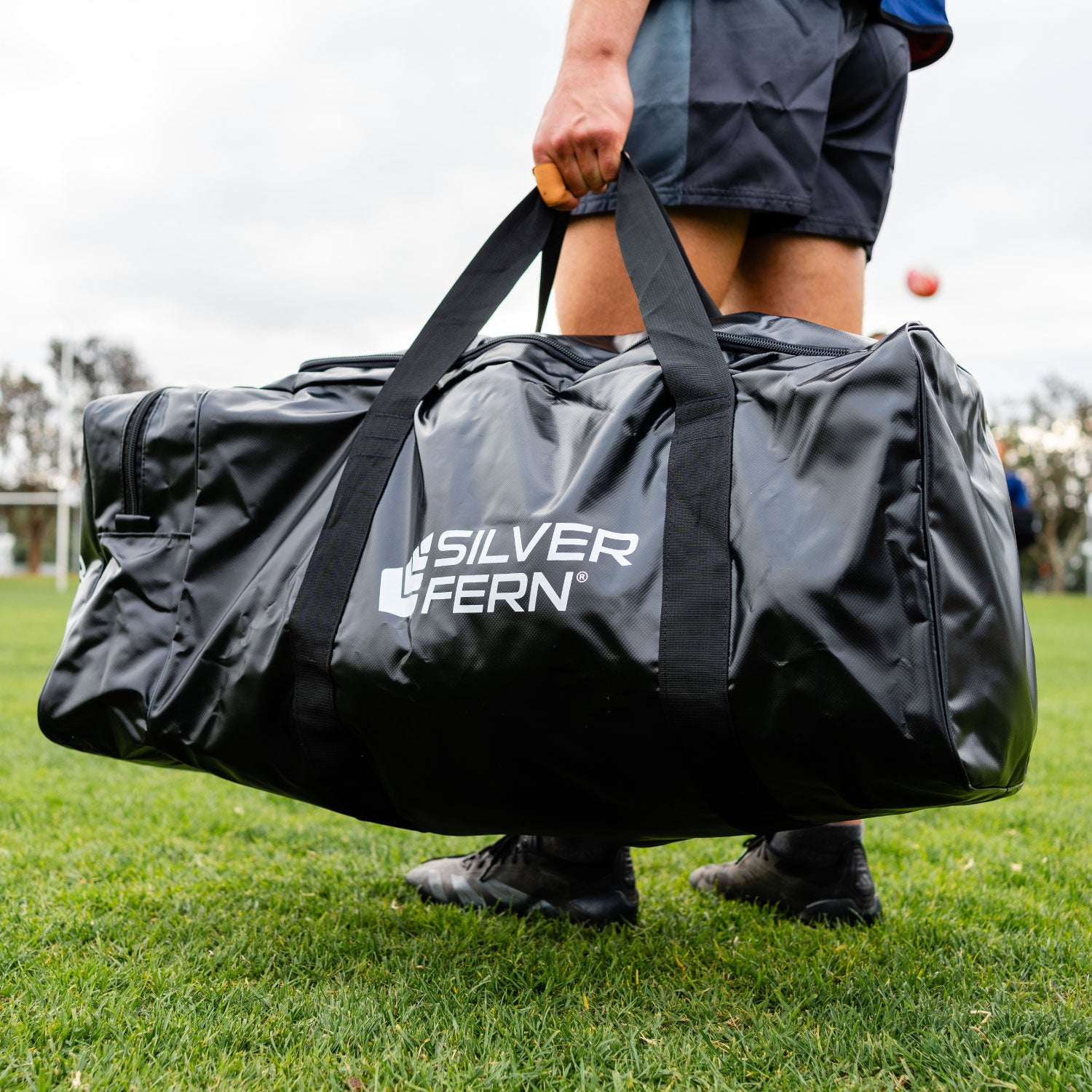 Silver Fern Black Large PVC Gear Bag, lifestyle shot, athlete holding the bag.