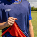 Reversible Rugby Tackle Bib, Blue/Red colourway, close-up lifestyle shot, rugby player pulling the bib