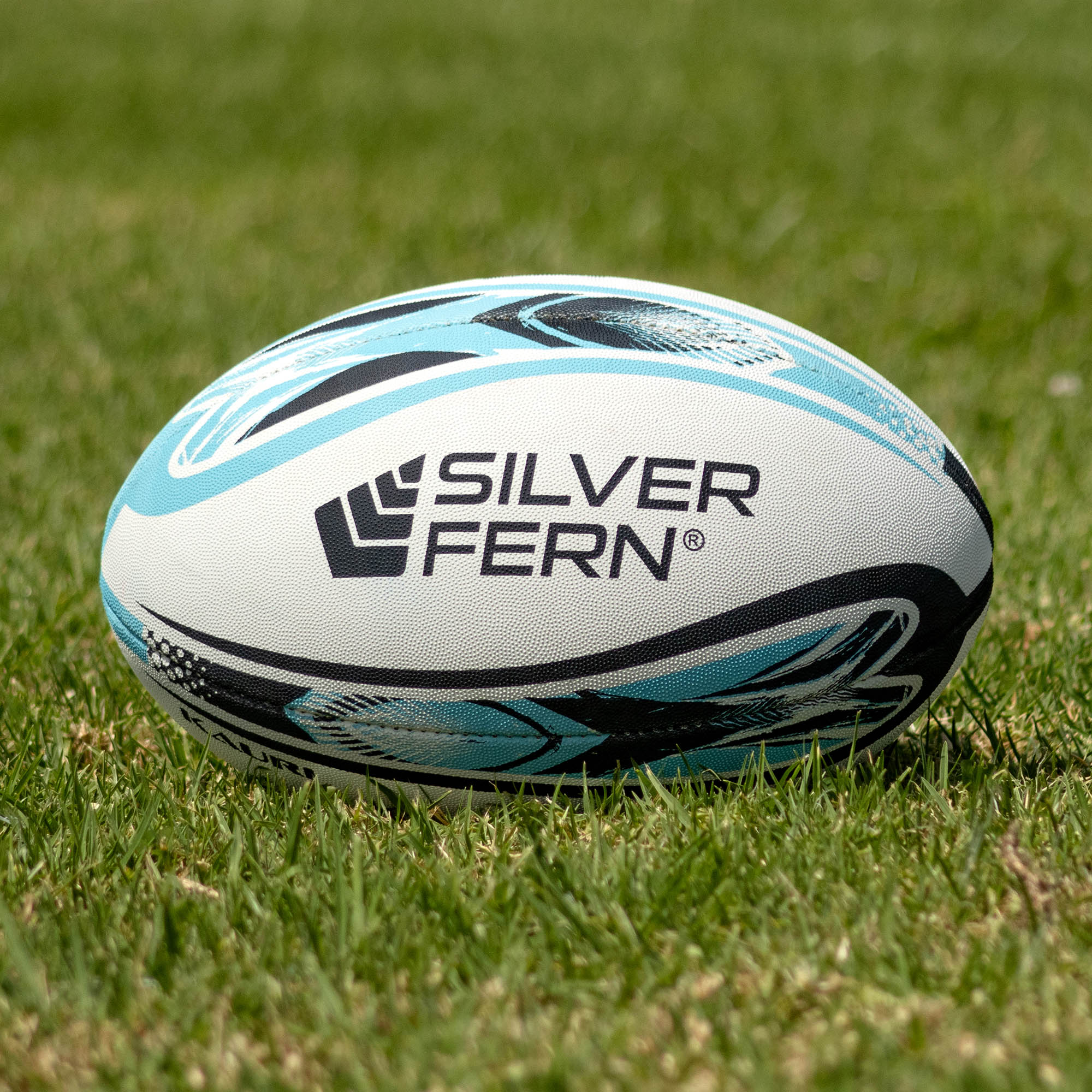 Silver Fern League Club Trainer Size 5, Lifestyle shot, sitting on a rugby field

