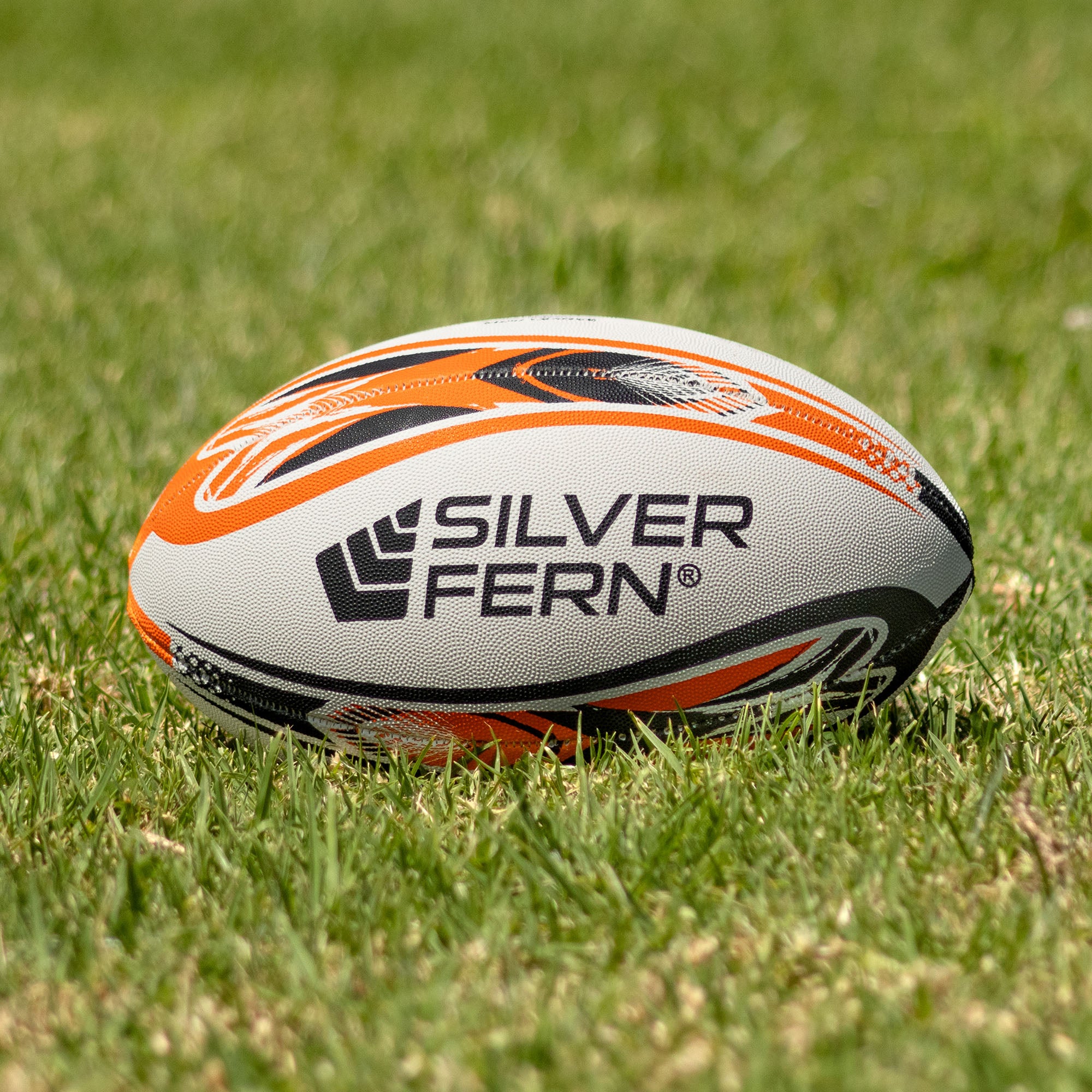 Silver Fern League Mini Trainer Size 3, Lifestyle shot, sitting on a rugby field

