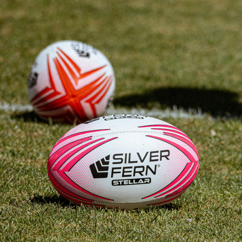 Silver Fern Stellar Premium Trainer Rugby Ball hero shot, two Stellar balls sitting on a rugby field