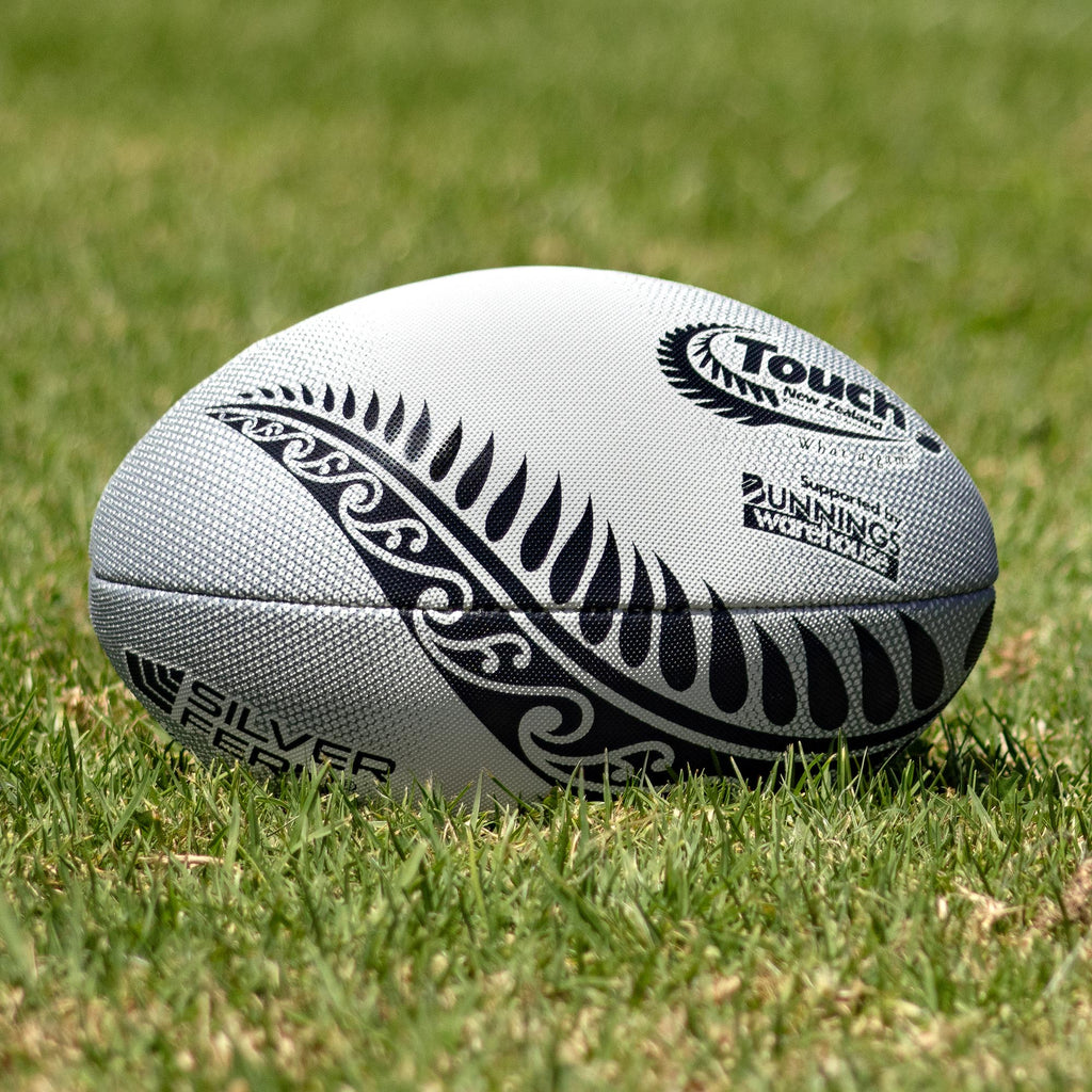 Silver Fern Touch Rugby Ball Stealth Match, Lifestyle shot, sitting on a rugby field