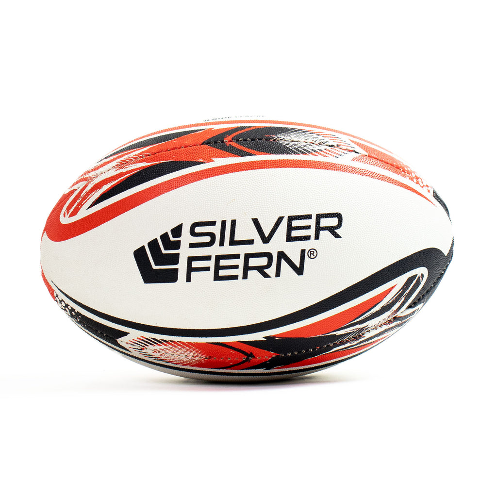 White rugby ball with red and black patterns and 'Silver Fern' branding on a white background